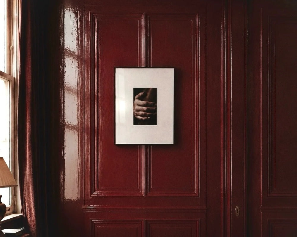 Framed photographic study on a deep red paneled wall